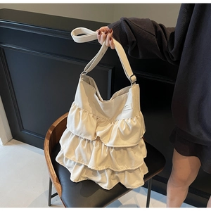 Detailansicht der cremefarbenen Canvas-Tasche mit dreilagigem Rüschendesign