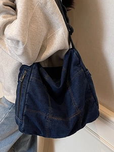 Minimalist deep blue denim tote bag with visible stitching and a side zipper pocket