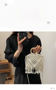 Close-up of bohemian hand-woven cream cotton bag with fringe detail and wooden handles