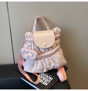 Detail of pink pleated backpack showing soft fabric texture and cute matching bow pouch