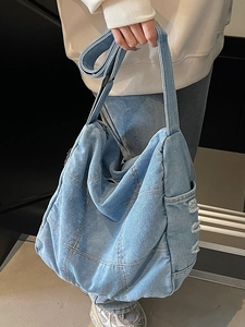 Minimalist light blue denim tote bag with patchwork squares and a wide shoulder strap