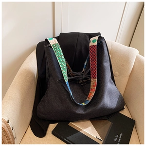 Detail of bohemian tote bag with colorful ethnic patterned wide shoulder strap on a sofa