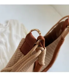 Detail of woven tote bag featuring gold circular hardware and texture of brown knit fabric