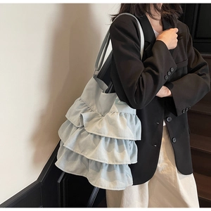 Detailansicht der staubblauen Canvas-Tasche mit Rüschen am Model zur Darstellung
