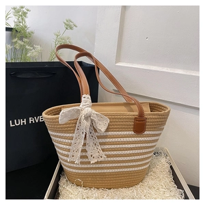 Detailed texture of beige woven tote bag featuring white stripes and lace bow decoration