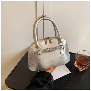 Close-up of metallic silver shell handbag with smooth texture and double zip closure
