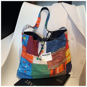 Detail of colorful patchwork tote bag showing eclectic patterns and drawstring closure