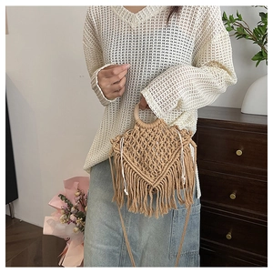 Close-up of bohemian macrame woven bag with fringe, wooden handles and canvas lining