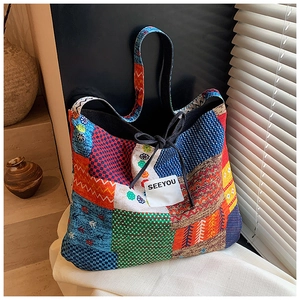 Detail of bohemian patchwork tote bag fabric with geometric patterns and rope detail