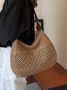 Hollow straw woven tote bag with brown leather shoulder strap for summer vacation