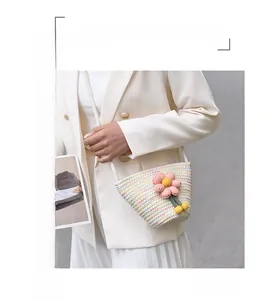 Detailed close-up of a colorful hand-woven bucket bag with a pink 3D knitted flower