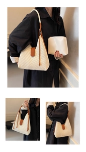 Detail of woven cream tote bag with triangle shape, leather buckle and shoulder strap