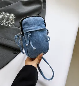 Detailed view of light blue washed denim mini crossbody bag with a decorative front knot