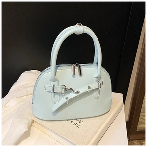 Close-up of light blue shell bag with double zippers and metallic eyelet strap detail