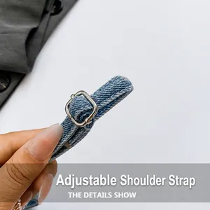 Detail of adjustable blue denim shoulder strap with silver metal buckle on crossbody bag