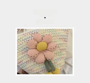 Detailed close-up of handmade woven floral bucket bag with pink flower knit decoration