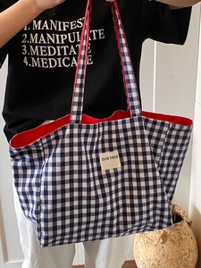 Spacious blue and white gingham tote bag with red lining and a woven brand label
