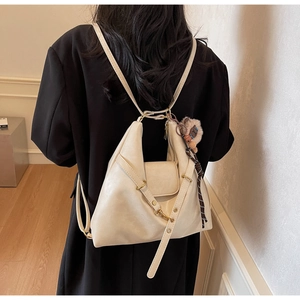 Detail of cream white soft leather hobo bag with gold hardware and plush bear charm