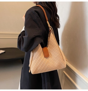 Detail of woven chevron pattern and brown leather strap on minimalist tote bag