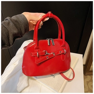 Detailed macro view of bright red shell bag in glossy patent leather with dual zippers