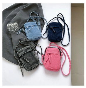 Detailed flat lay of small washed denim crossbody bags in four distinct colors