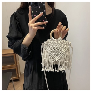 Close-up of bohemian hand-woven cotton bag with geometric patterns and fringe detail