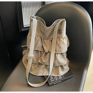 Makro-Detail einer grauen Rüschen-Tasche mit Vintage-Waschung und verstellbarem Riemen