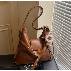 Detail of vintage brown leather tote bag with FASHION & BAGS logo and cute bear pendant