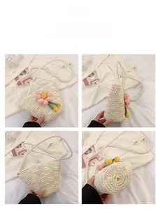 Detail view of colorful woven bucket bag with 3D pink crochet flower and long strap