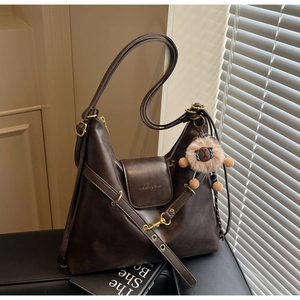 Detail of dark brown tote bag with soft leather texture and fashion embossed text