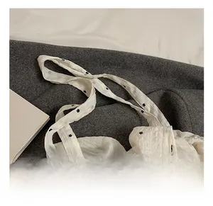 Detail of comfortable shoulder strap on white floral tote bag with textured chiffon fabric