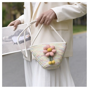 Handwoven mini straw bucket bag with knit flower and colorful rainbow weaving pattern