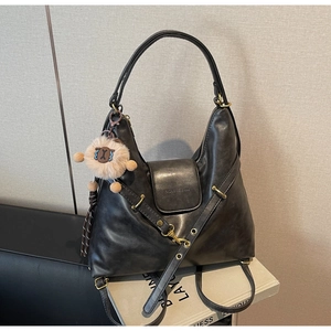 Detail of black faux leather tote featuring fashion engraving and a cute sheep charm
