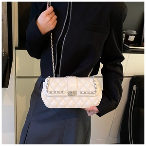 Detailed view of cream quilted crossbody bag with elegant gold-tone chain strap