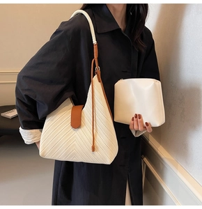 Detail view of woven shoulder bag with thick spiral rope strap and small pouch