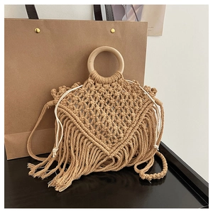 Detail of macrame woven tote bag featuring round wooden handles and long tassels
