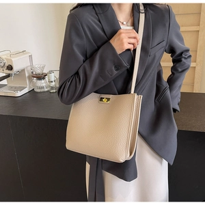 Detail of lychee pattern leather bucket bag with golden twist lock for women