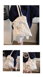 Close-up of white chiffon tote bag with black floral print and ruffled magic pocket detail