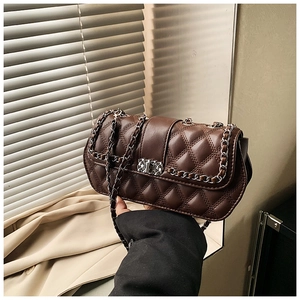 Detailed view of dark brown quilted crossbody bag with silver chain and twist lock clasp
