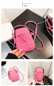 Pink washed denim mini crossbody bag with zipper compartments and knotted rope details