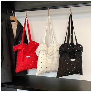 Detailed shot of ruffled chiffon tote bags in red, black, and white with polka dot patterns
