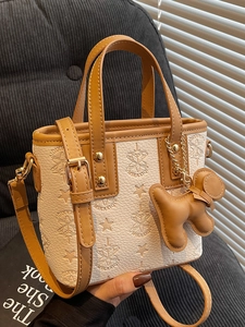 Sac seau gaufré beige tendance avec garniture en cuir marron et accessoire de charme chiot