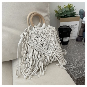 Detail of bohemian beige woven cotton bag showing V-pattern texture and wood handles