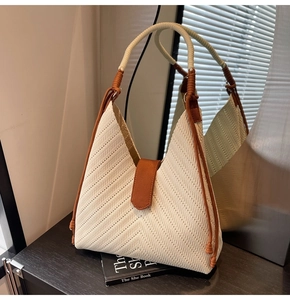 Detail of woven tote bag featuring cream herringbone texture and vintage knot handle