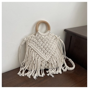 Close-up of bohemian macrame bag with round wooden handle and long fringe tassels