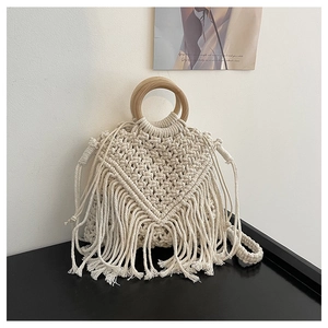 Detail of bohemian woven cotton bag featuring intricate V-shaped patterns and long tassels