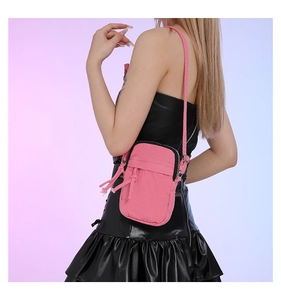 Detailed view of pink denim mini crossbody bag with drawstring design and zipper closure