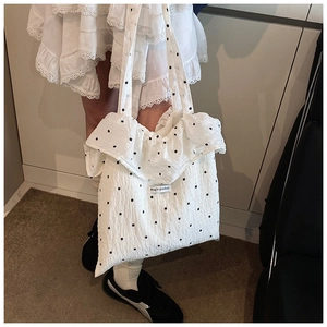 Close-up of white chiffon tote bag with black star patterns and ruffle edge detail