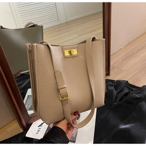 Close-up of beige lychee grain leather bucket bag with gold metal buckle and adjustable strap