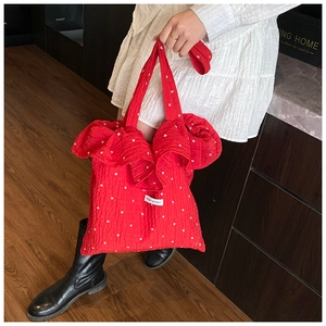 Detailed view of red ruffled chiffon bag with floral patterns and Magic pocket label